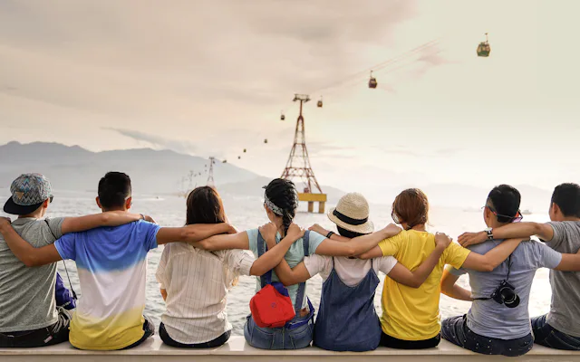 A barkada sitting together arm in arm, looking out over a scenic view
